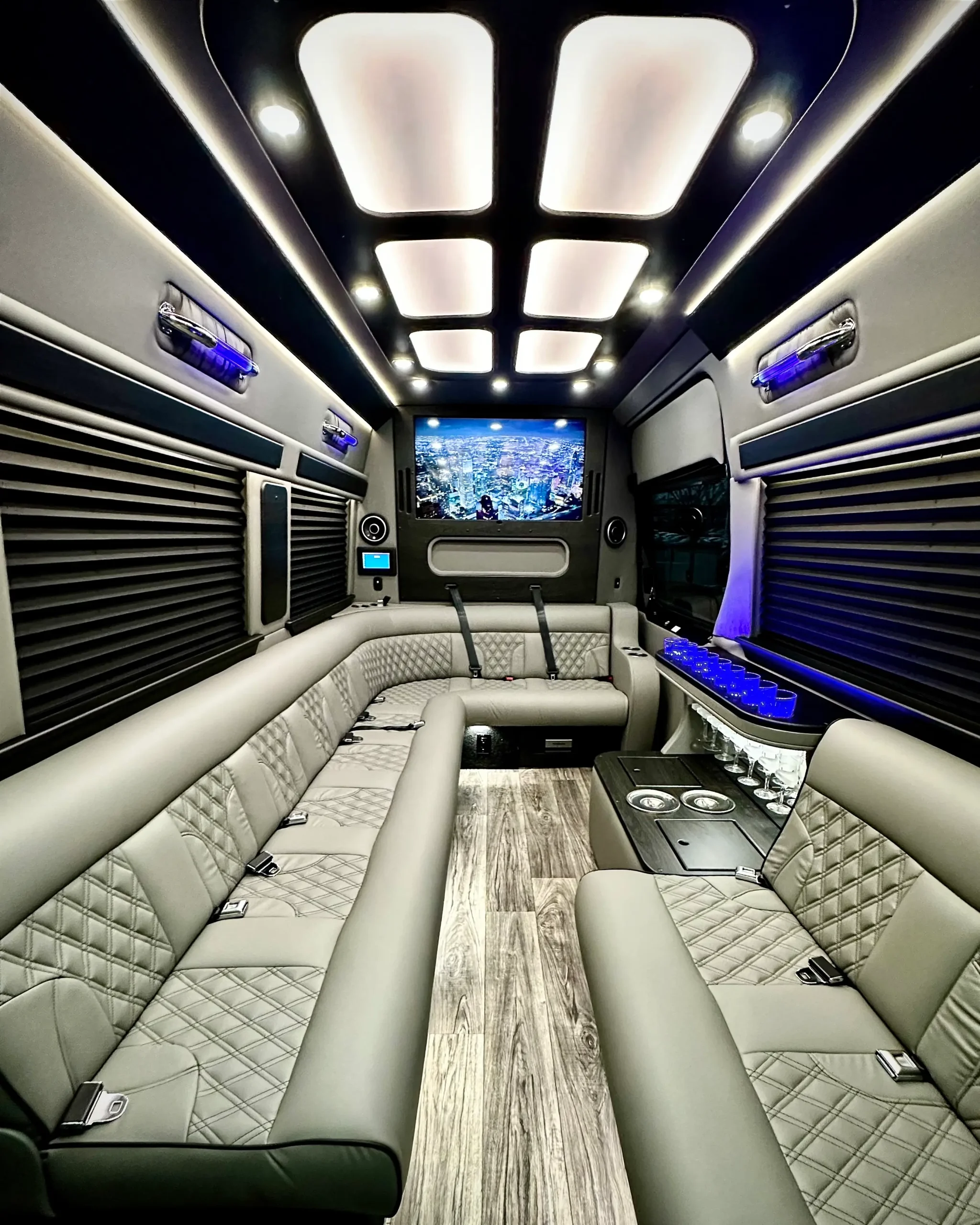 interior view of limo bus facing front toward flat screen tv and bar